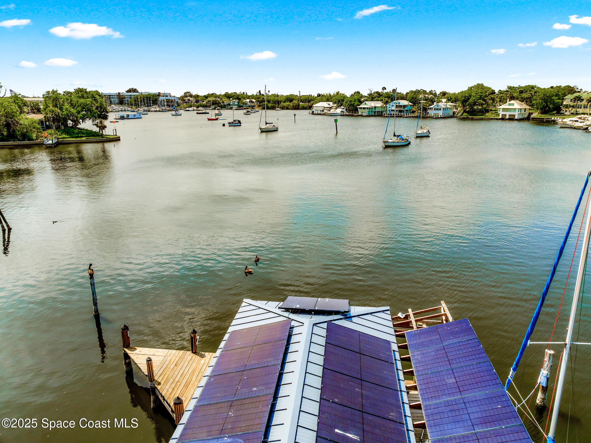 1025 Terry Drive Melbourne, FL 32935 - Photo 9 of 72 a view of a lake with boats and trees in the background