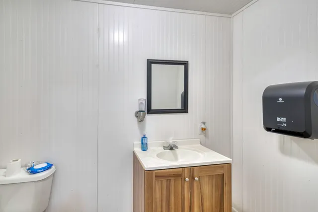 a bathroom with a toilet sink and mirror