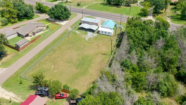 an aerial view of a house with swimming pool and large trees