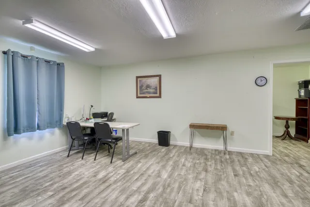 a view of a workspace with furniture and a window