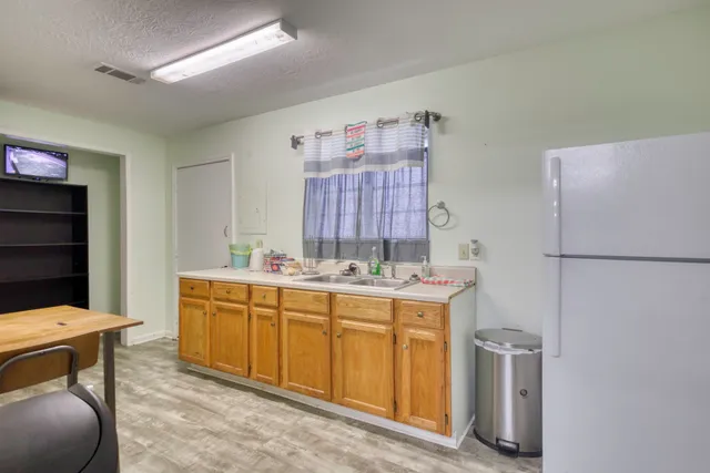 a kitchen with a sink a refrigerator and cabinets