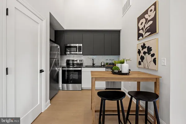 a kitchen with granite countertop white cabinets and black appliances