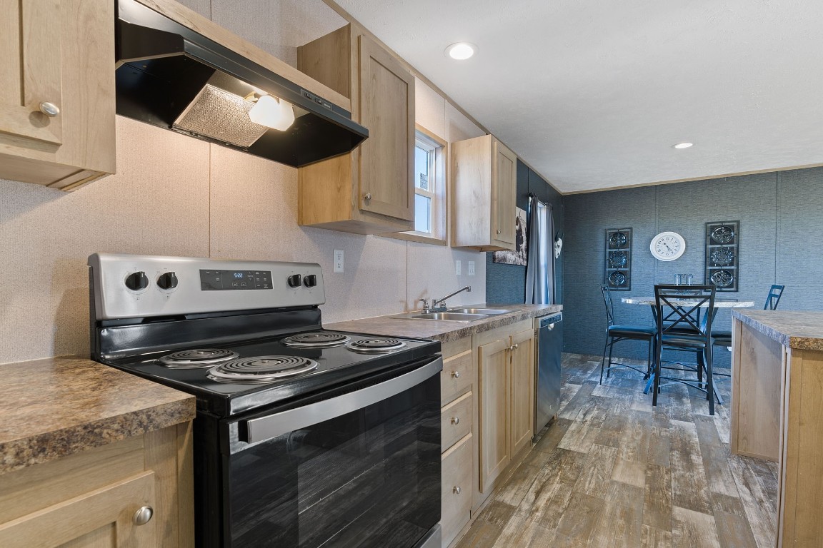 5897 Old Colony Line Road Lockhart, TX 78644 - Photo 25 of 40 a kitchen with stainless steel appliances a stove a sink dishwasher and cabinets with wooden floor