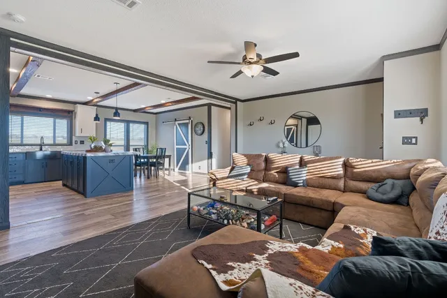 a living room with furniture a chandelier and a window