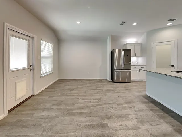 a view of kitchen with refrigerator and window