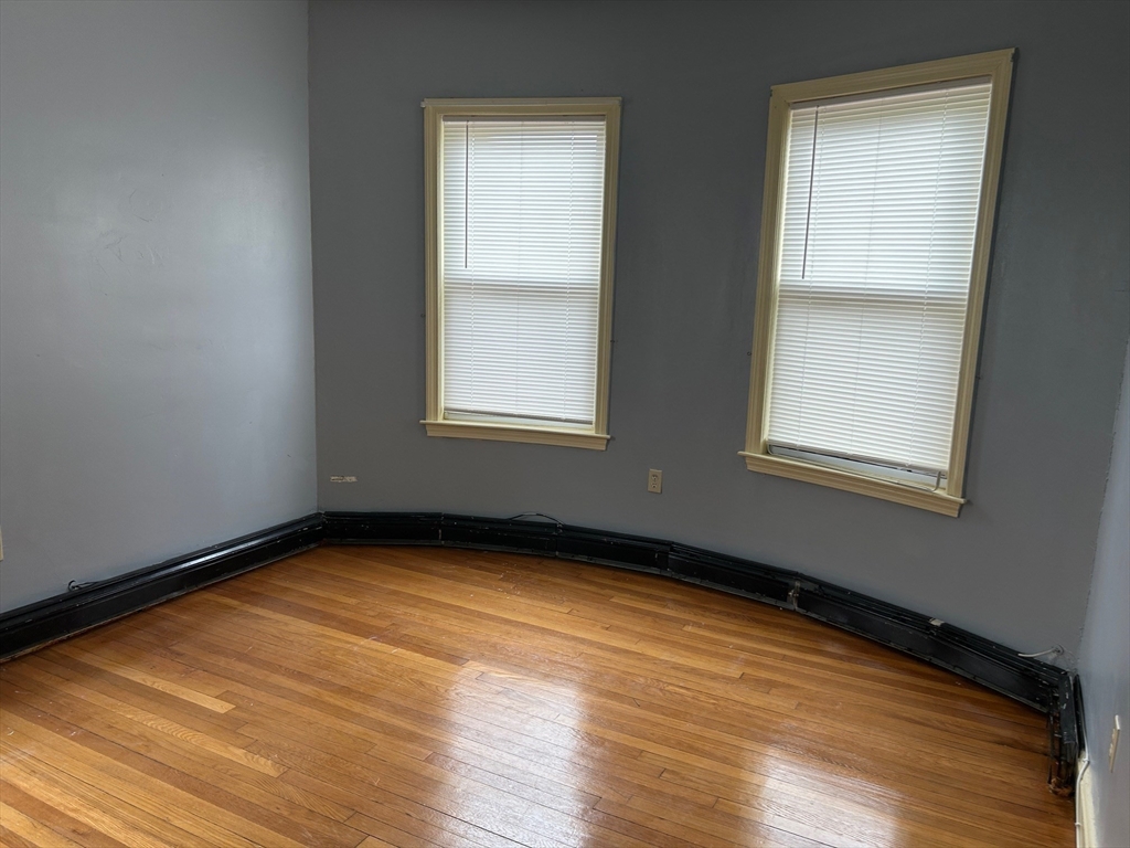 15 Harlem Street, Unit 3 Boston, MA 02121 - Photo 9 of 14 an empty room with wooden floor and windows