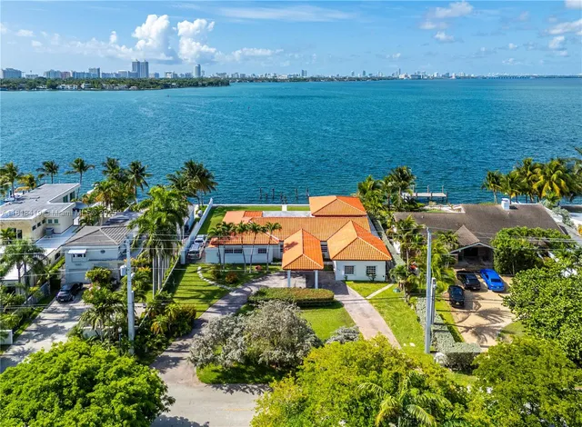 an aerial view of residential houses with outdoor space and ocean view