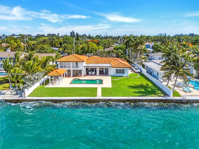 a view of a house with a big yard and large trees