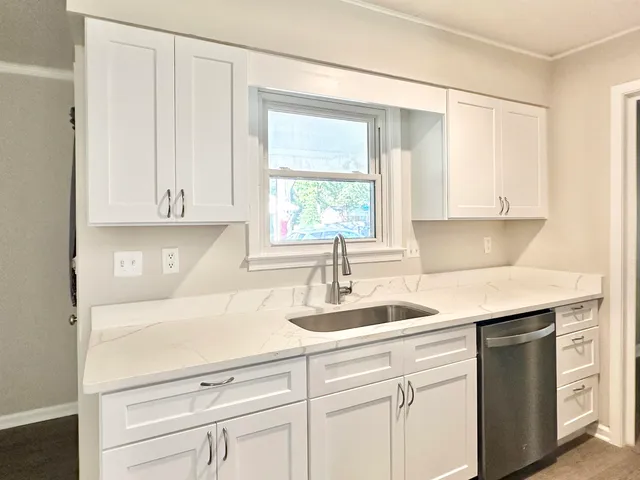 a kitchen with a sink cabinets and window