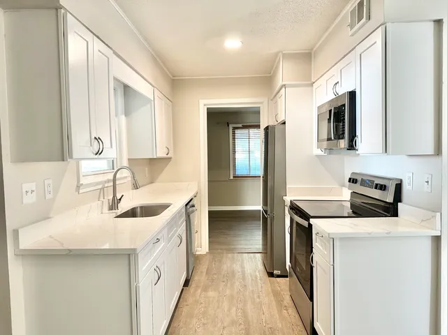 a kitchen with a sink stove and refrigerator