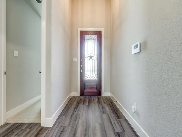 a view of a hallway with wooden floor and a window