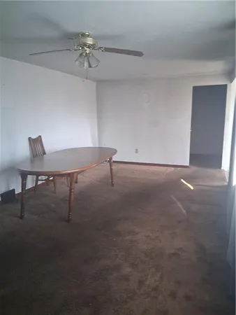 a view of a room with a ceiling fan and a window