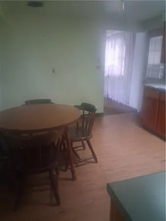 a view of a room that has a window and a table in it