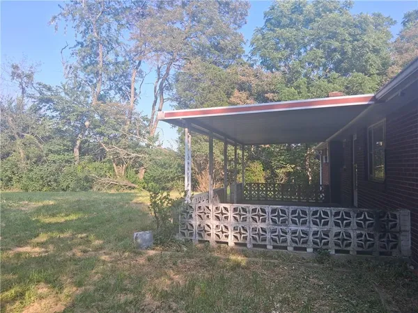 a view of a yard with table and chairs under an umbrella