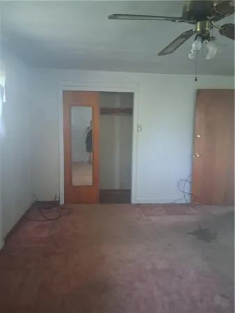 an empty room with chandelier fan