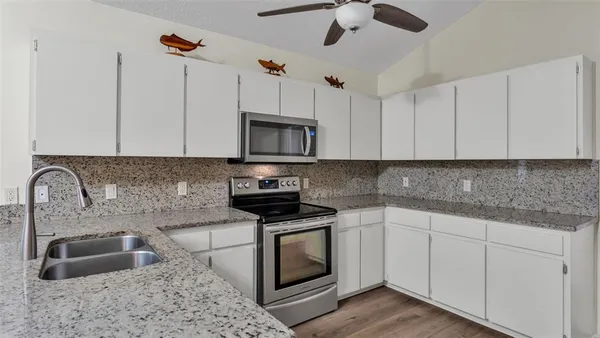 a kitchen with stainless steel appliances a stove sink microwave and cabinets