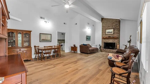 a living room with furniture a fireplace and kitchen view