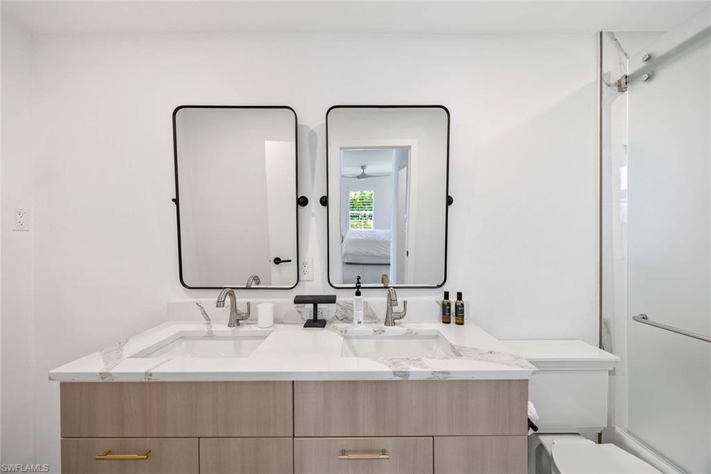 24 Rivard Road Naples, FL 34112 - Photo 23 of 33 a bathroom with double vanity sinks and a mirror