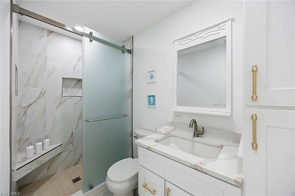 24 Rivard Road Naples, FL 34112 - Photo 26 of 33 a bathroom with a granite countertop sink toilet and shower