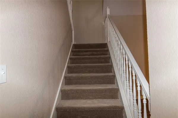 a view of staircase with wooden floor and white walls