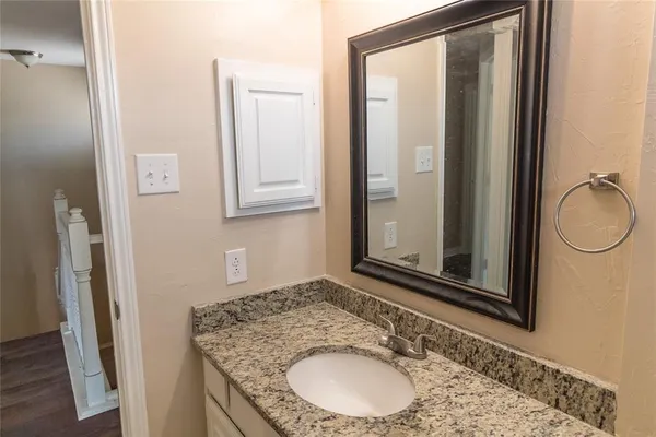 a bathroom with a granite countertop sink and a mirror