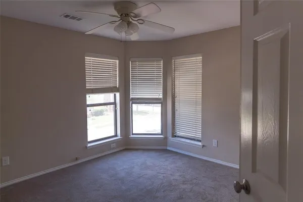 a view of empty room with windows and chandelier fan