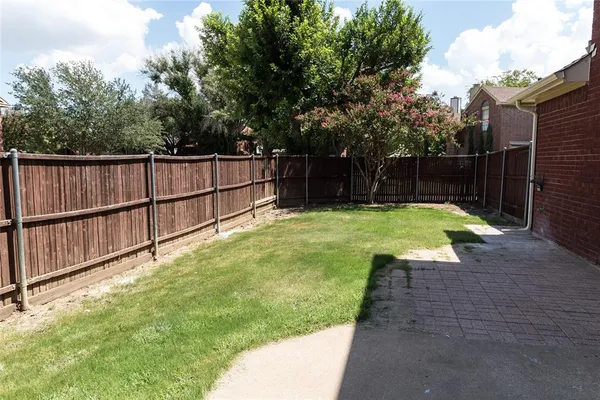 a view of a backyard with wooden fence