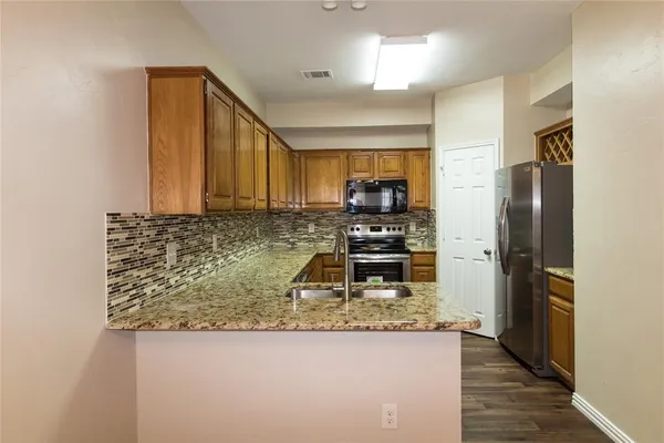 a kitchen with stainless steel appliances granite countertop a refrigerator stove and oven
