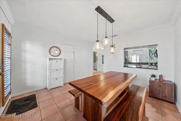 a living room with a table chairs and a flat screen tv