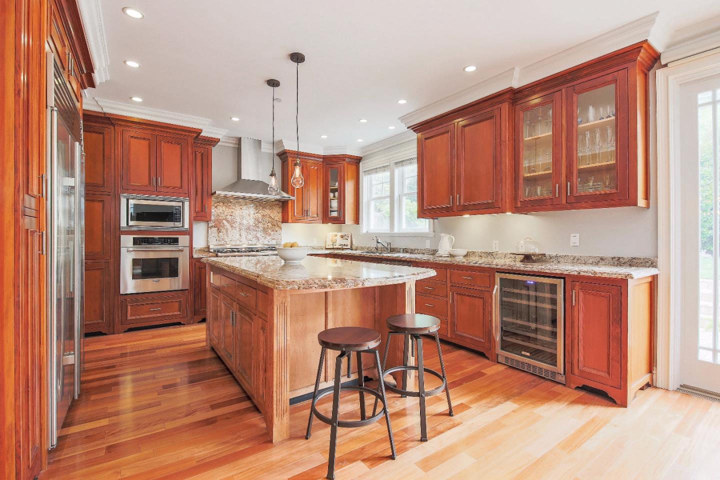 1637 Westmoor Road Burlingame, CA 94010 - Photo 21 of 54 a kitchen with kitchen island granite countertop wooden cabinets and a refrigerator