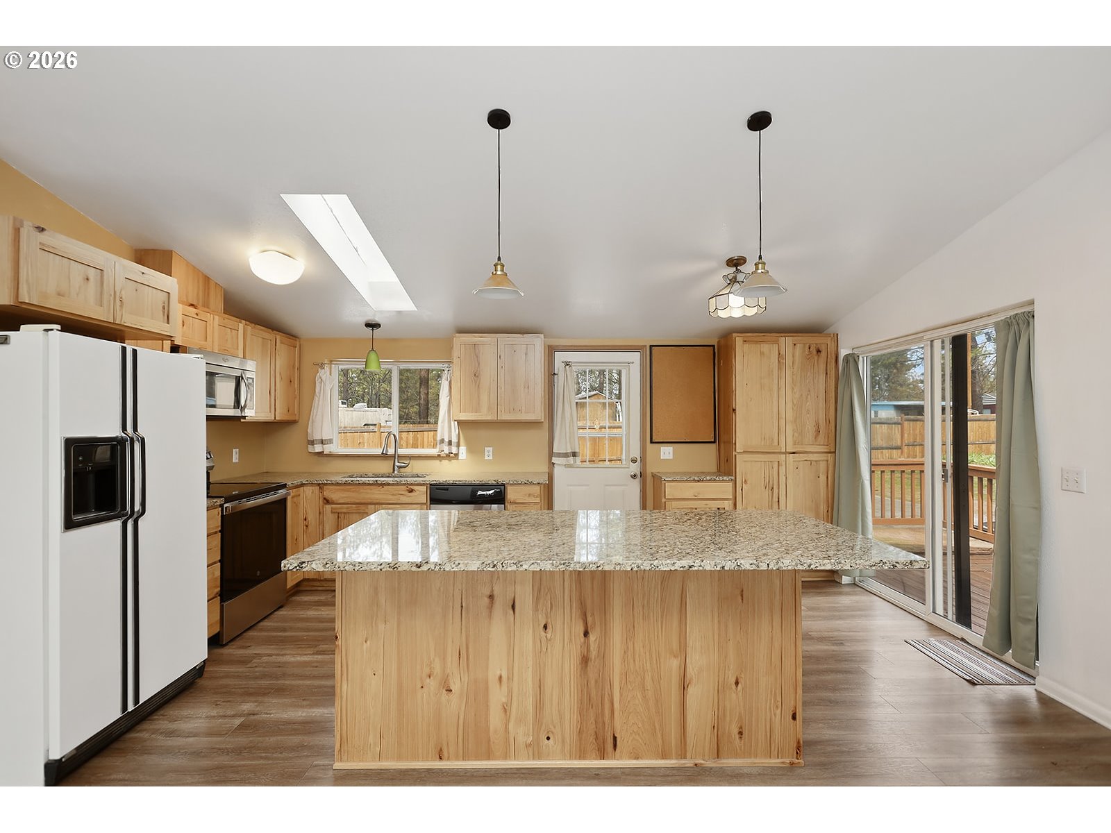 39 North Eagle Point Road Tygh Valley, OR 97063 - Photo 7 of 34 a kitchen with stainless steel appliances granite countertop a sink a refrigerator and a wooden cabinets