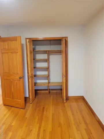 a view of room with wooden floor and brick walls