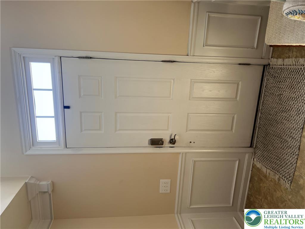 8549 Gateway Road Breinigsville, PA 18031 - Photo 2 of 26 An inviting entrance with a classic panel door and a side light, complemented by wainscoting.