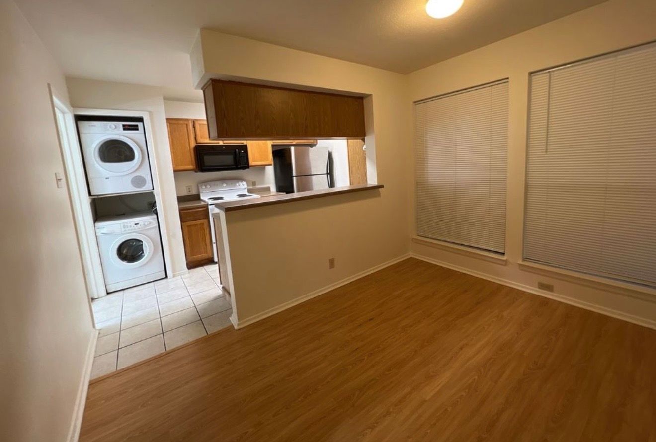 3115 Helms Street, Unit 111 Austin, TX 78705 - Photo 3 of 13 A well-designed kitchen and dining area features sleek flooring and convenient laundry amenities.