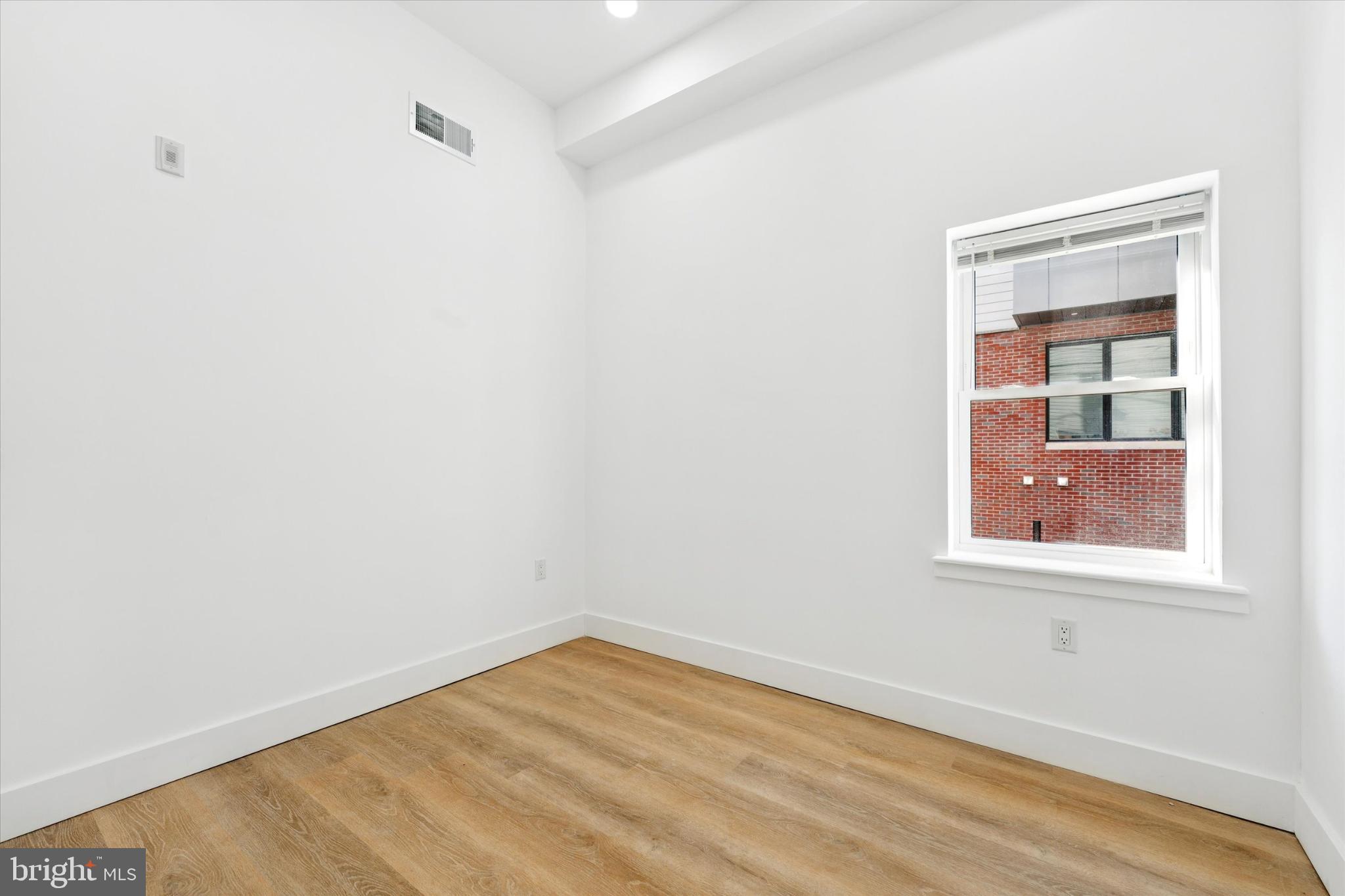 2424 West Thompson Street, Unit 3 Philadelphia, PA 19121 - Photo 12 of 14 a view of an empty room with wooden floor and a window