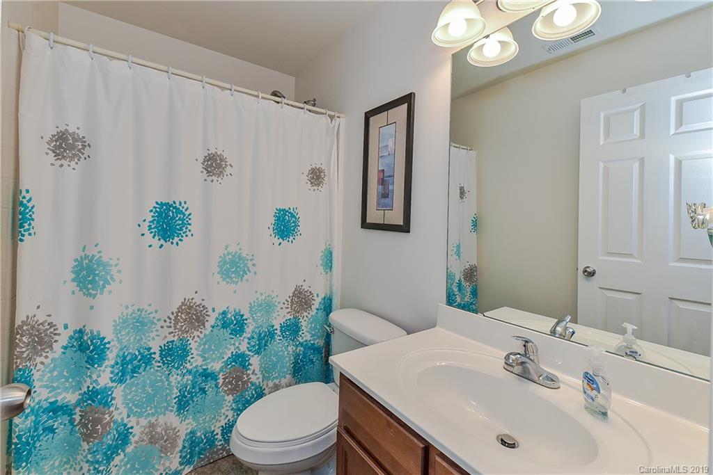 10818 Greenhead View Road Charlotte, NC 28262 - Photo 30 of 39 a bathroom with a sink a toilet and shower curtain