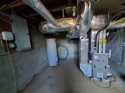 a backyard of a house with barbeque oven and trees