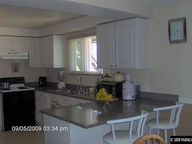 1235 Autumn Reno, NV 89511 - Photo 3 of 9 a kitchen with stainless steel appliances granite countertop a sink a stove a dining table and chairs