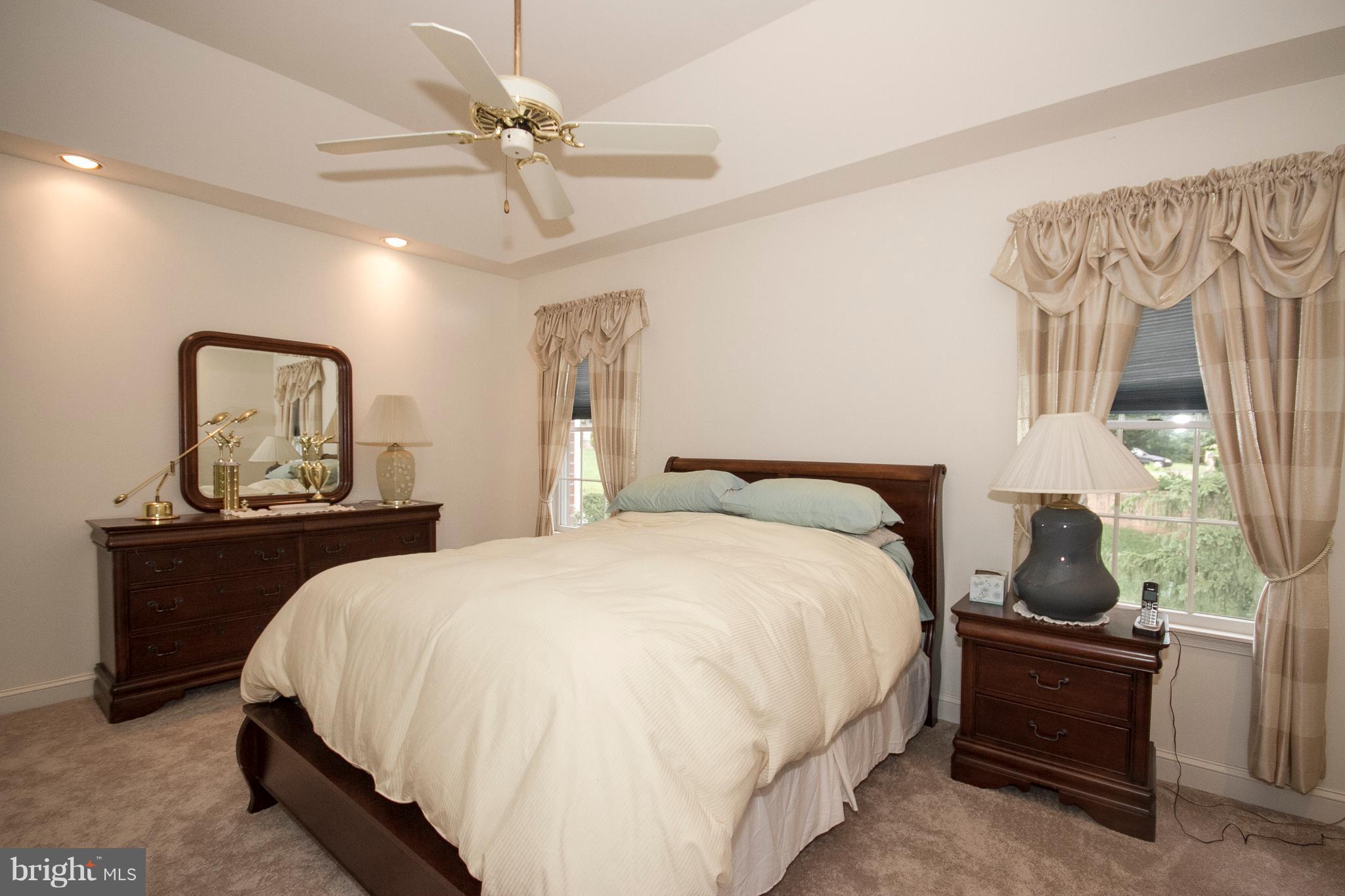 4 Roland Place Bel Air, MD 21014 - Photo 15 of 22 a large bed sitting in a bedroom next to a window and a chandelier