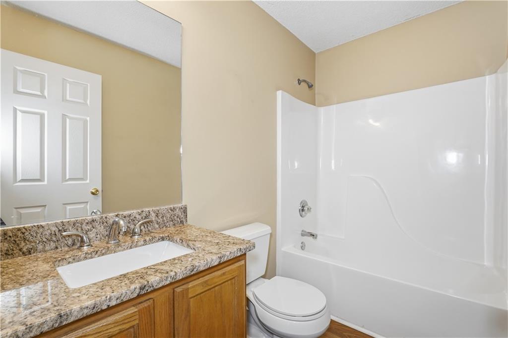 1488 Bellemeade Farms Road Southwest Marietta, GA 30008 - Photo 19 of 31 a bathroom with a granite countertop sink a toilet and shower