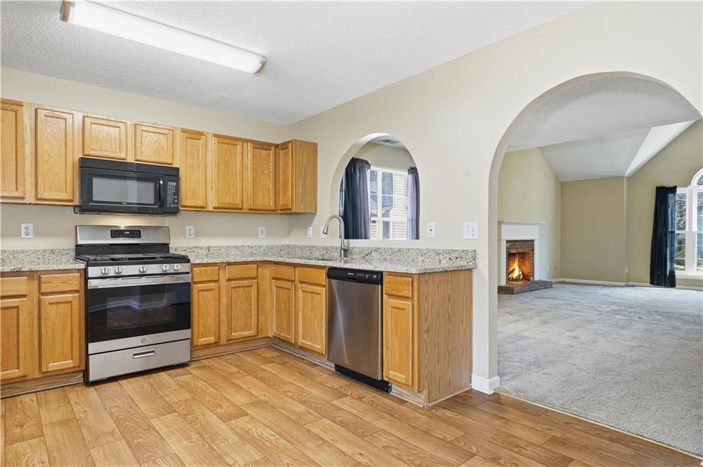 1488 Bellemeade Farms Road Southwest Marietta, GA 30008 - Photo 10 of 31 a kitchen with stainless steel appliances granite countertop a stove a sink and a refrigerator