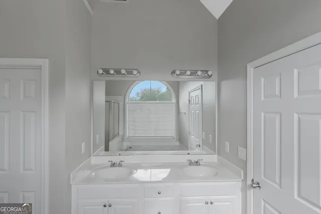 a bathroom with a sink vanity granite and a mirror