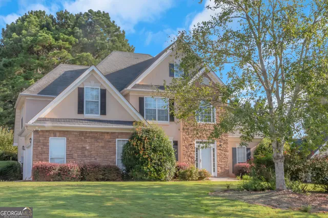 a front view of a house with a garden