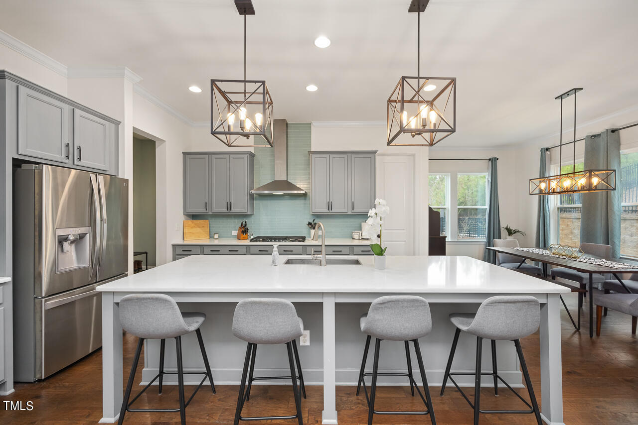 5109 Landguard Drive Raleigh, NC 27613 - Photo 13 of 47 a kitchen with stainless steel appliances granite countertop a dining table chairs refrigerator and wooden floor