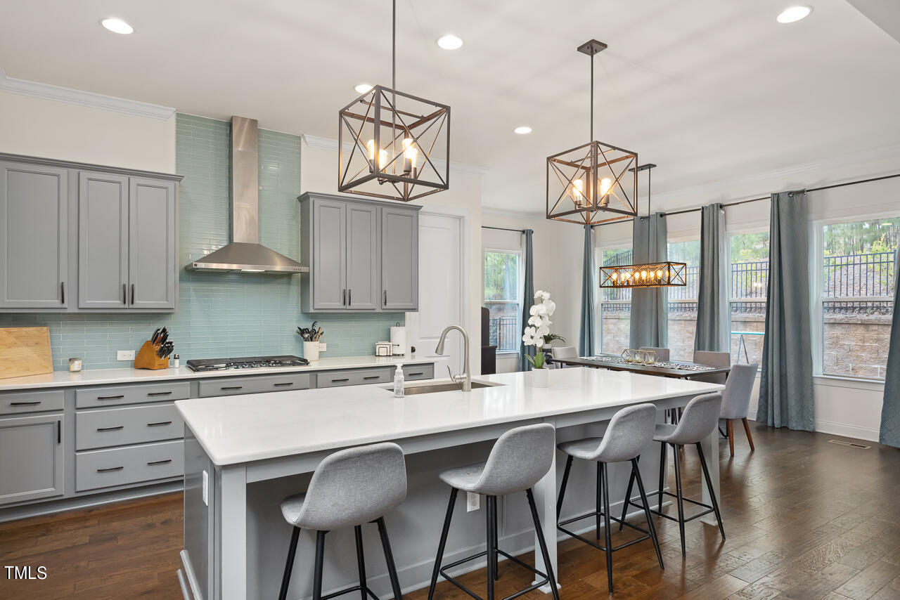 5109 Landguard Drive Raleigh, NC 27613 - Photo 14 of 47 a kitchen with stainless steel appliances granite countertop a dining table chairs and white cabinets