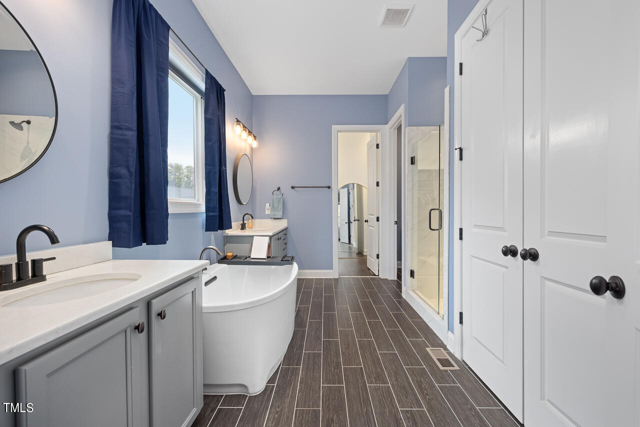5109 Landguard Drive Raleigh, NC 27613 - Photo 22 of 47 a bathroom with a sink a mirror a vanity and shower