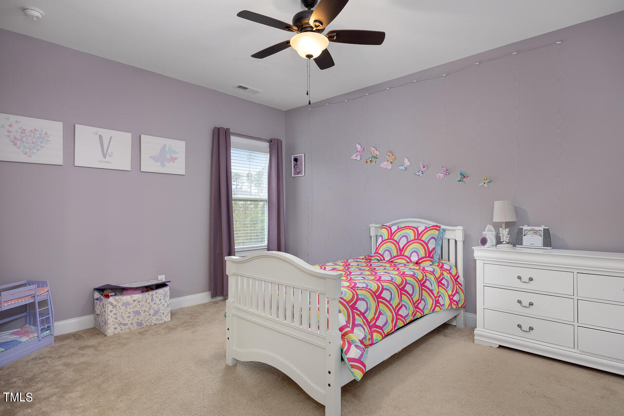 5109 Landguard Drive Raleigh, NC 27613 - Photo 32 of 47 a bedroom with a bed and a chandelier