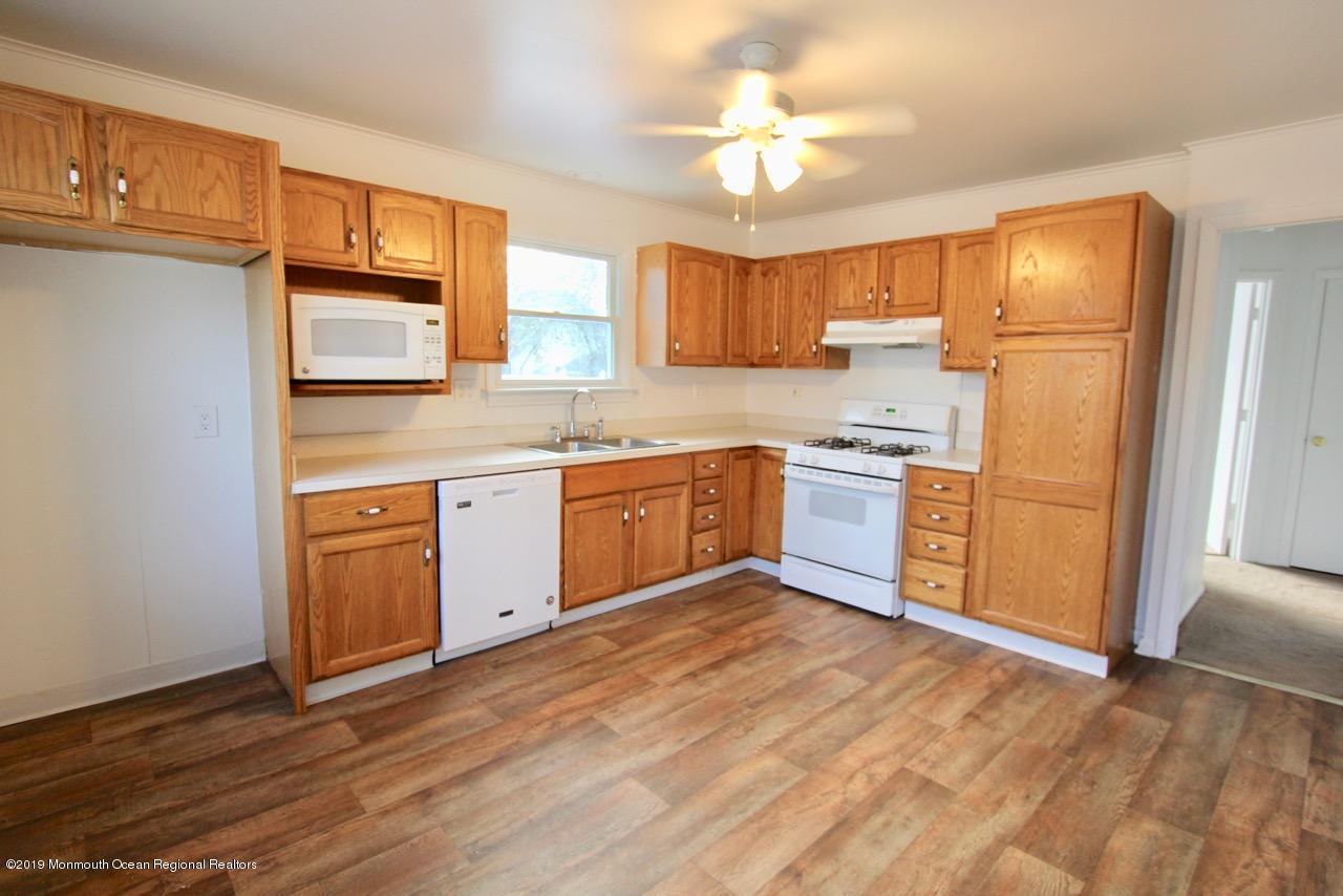 412 Ely Road Neptune Township, NJ 07753 - Photo 3 of 15 a kitchen with stainless steel appliances granite countertop a sink cabinets wooden floor and view living room