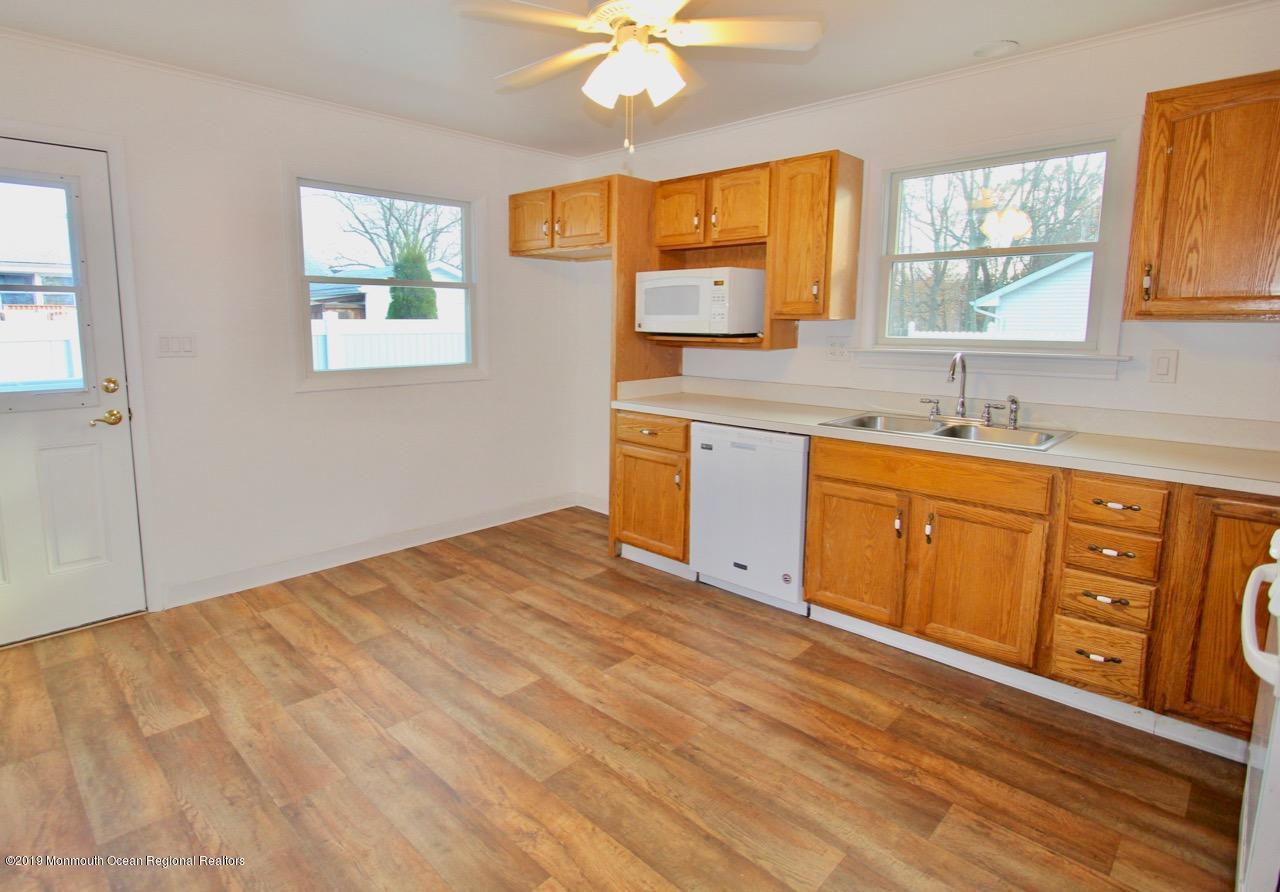412 Ely Road Neptune Township, NJ 07753 - Photo 4 of 15 a kitchen with stainless steel appliances granite countertop a sink cabinets and wooden floor