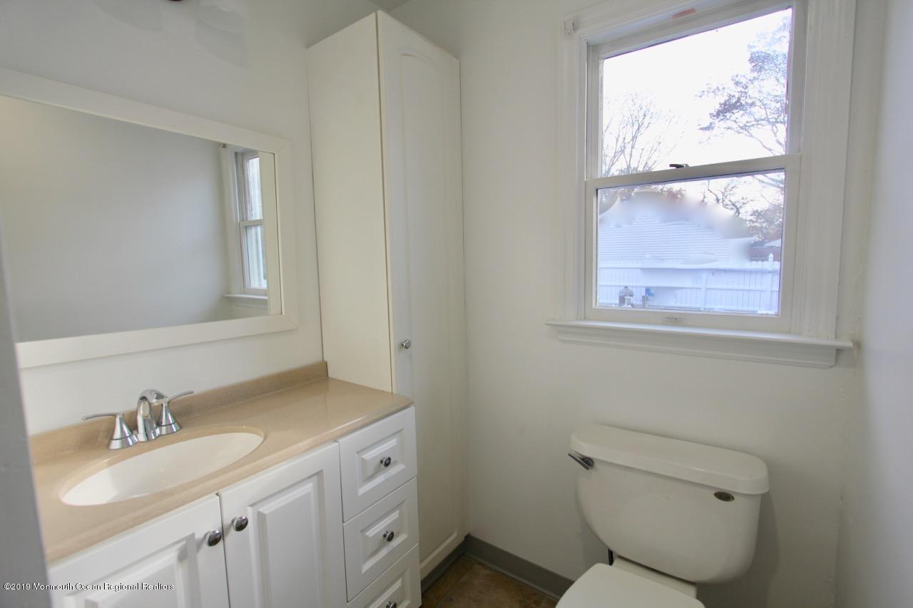 412 Ely Road Neptune Township, NJ 07753 - Photo 10 of 15 a bathroom with a granite countertop toilet sink and mirror